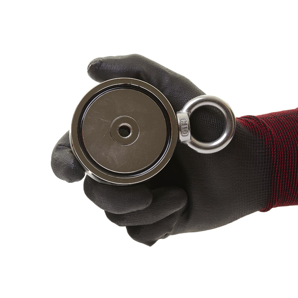 Detailaufnahme eines runden Magnetar Neodym-Bergemagneten mit Öse, gehalten in schwarzem Schutzhandschuh – stark für Magnetfischen.