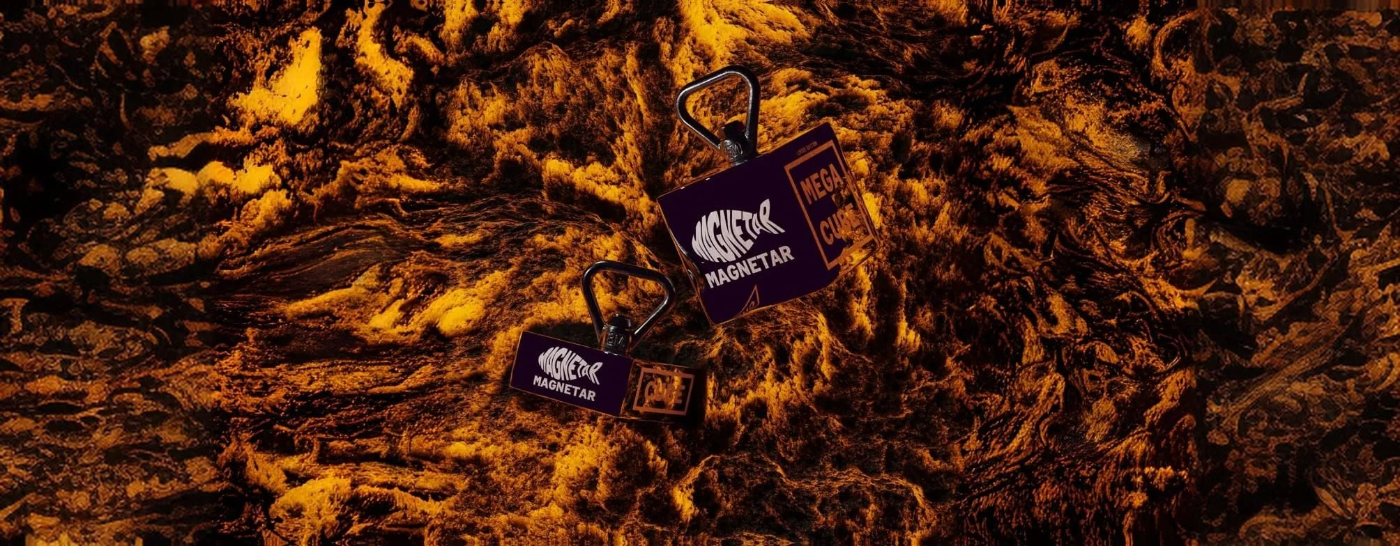 Zwei Magnetar Mega Cube Bergemagnete vor dramatischem feurigem Hintergrund – kraftvoll inszeniert für maximale Wirkung.