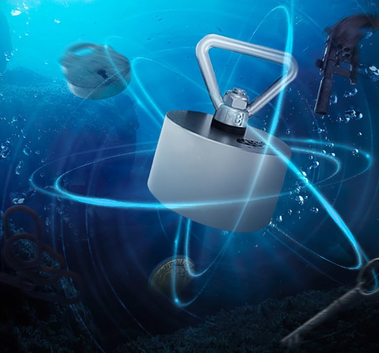 Lifestylebild eines massiven Neodym-Bergemagneten mit Dreiecksöse, der unter Wasser Metallobjekte wie Waffen, Schlösser und Münzen anzieht – optimal fürs Magnetfischen.